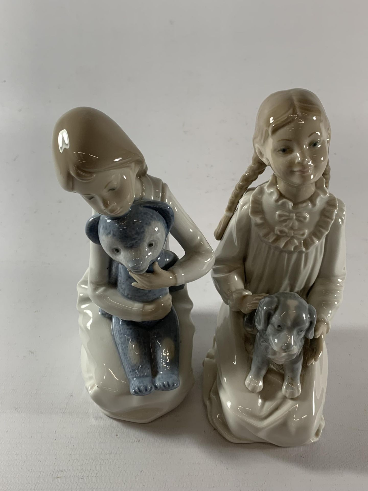 TWO NAO GIRL FIGURES - ONE WITH A DOLL AND ONE WITH A TEDDY BEAR
