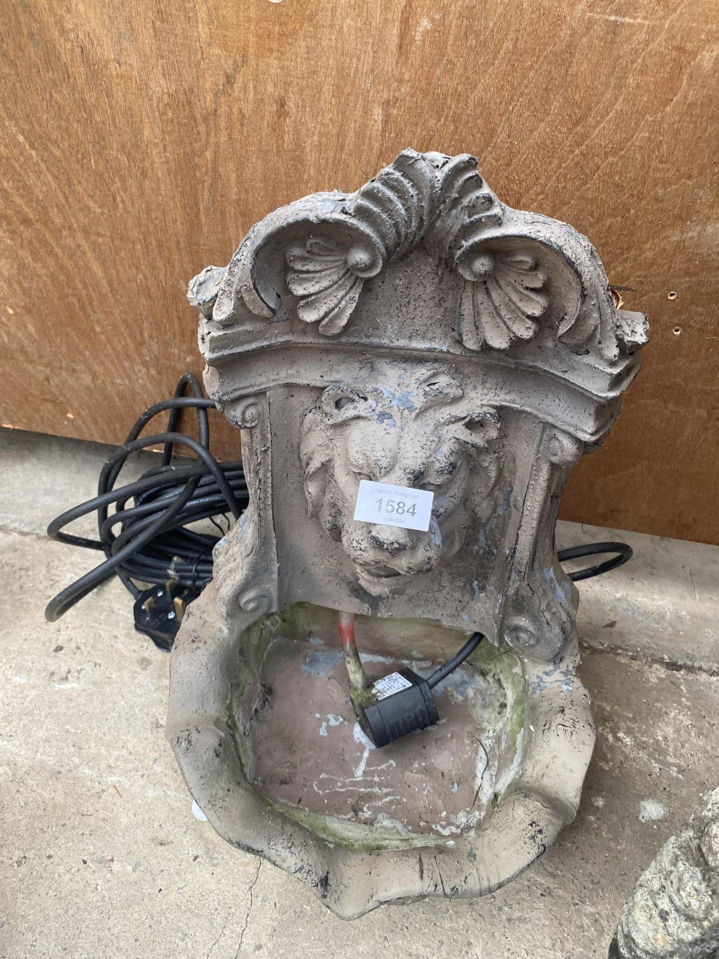 A PLASTIC WALL MOUNTED LION HEAD WATER FEATURE