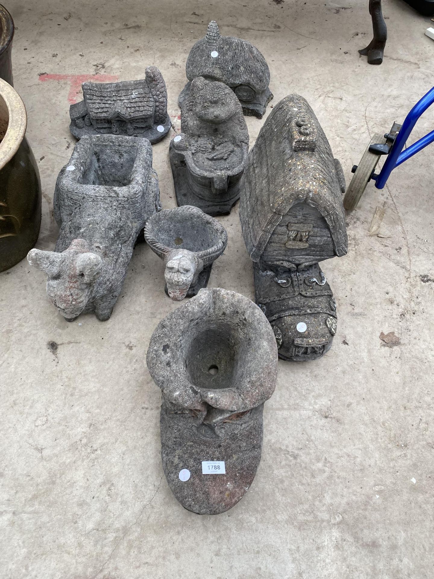 AN ASSORTMENT OF RECONSTITUTED STONE GARDEN ORNAMENTS TO INCLUDE BOOTS, COTTAGES AND PLANTERS ETC