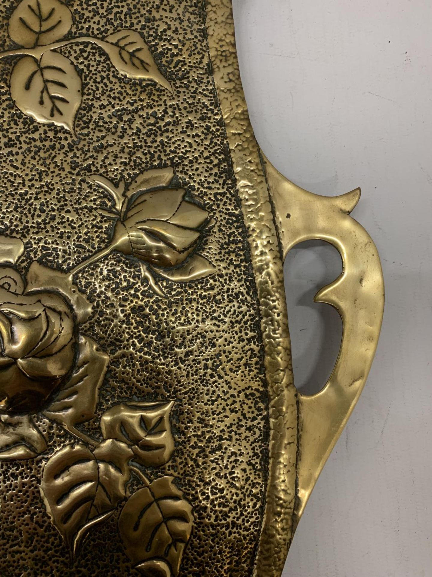 A BRASS WALL HANGING IN THE SHAPE OF A SHIELD WITH FLORAL EMBOSSING 46CM X 34CM - Image 2 of 3