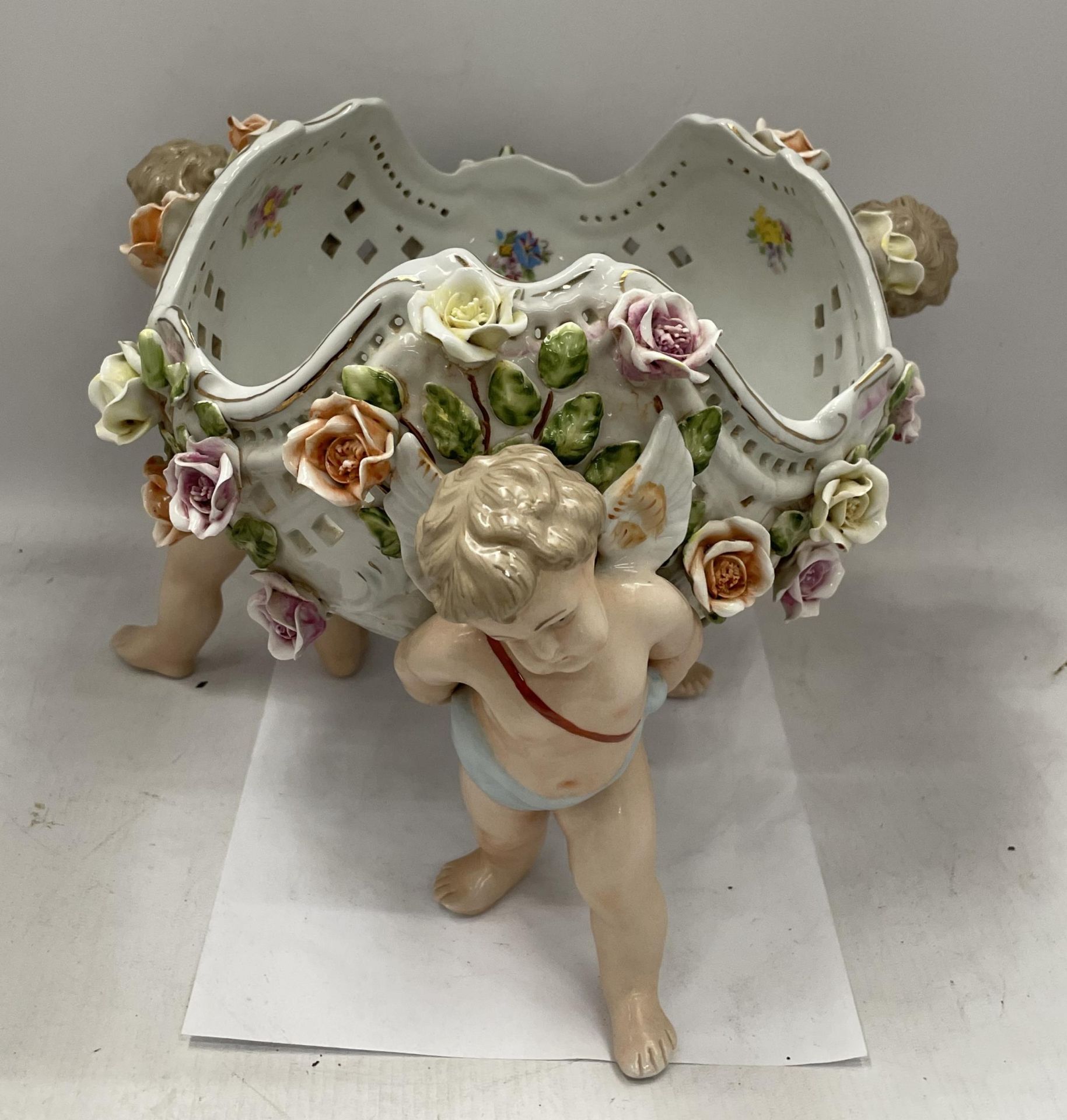 A CONTINENTAL PORCELAIN CHERUB DESIGN FLORAL ENCRUSTED BOWL WITH MEISSEN BLUE CROSS SWORDS MARK TO