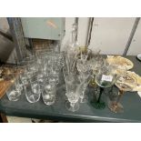 A QUANTITY OF GLASSES TO INCLUDE WINE, A DECANTER, CHAMPAGNE FLUTES, SHERRY, TUMBLERS, ETC