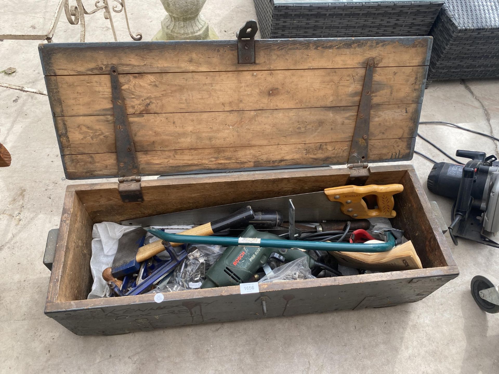A VINTAGE WOODEN TOOL CHEST CONTAINING AN ASSORTMENT OF TOOLS TO INCLUDE A WOOD PLANE AND AN AXE ETC