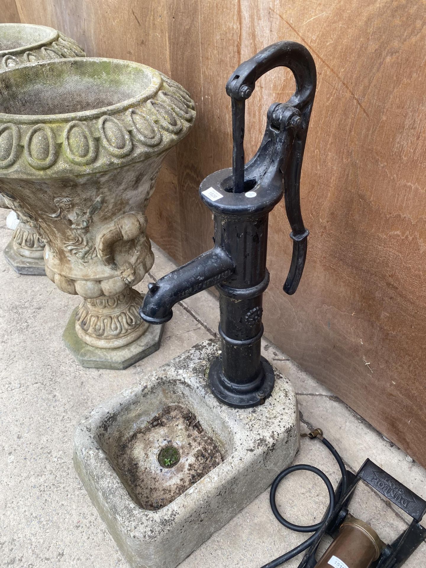 A VINTAGE CAST IRON WATER PUMP WITH A STONE TROUGH TO BASE