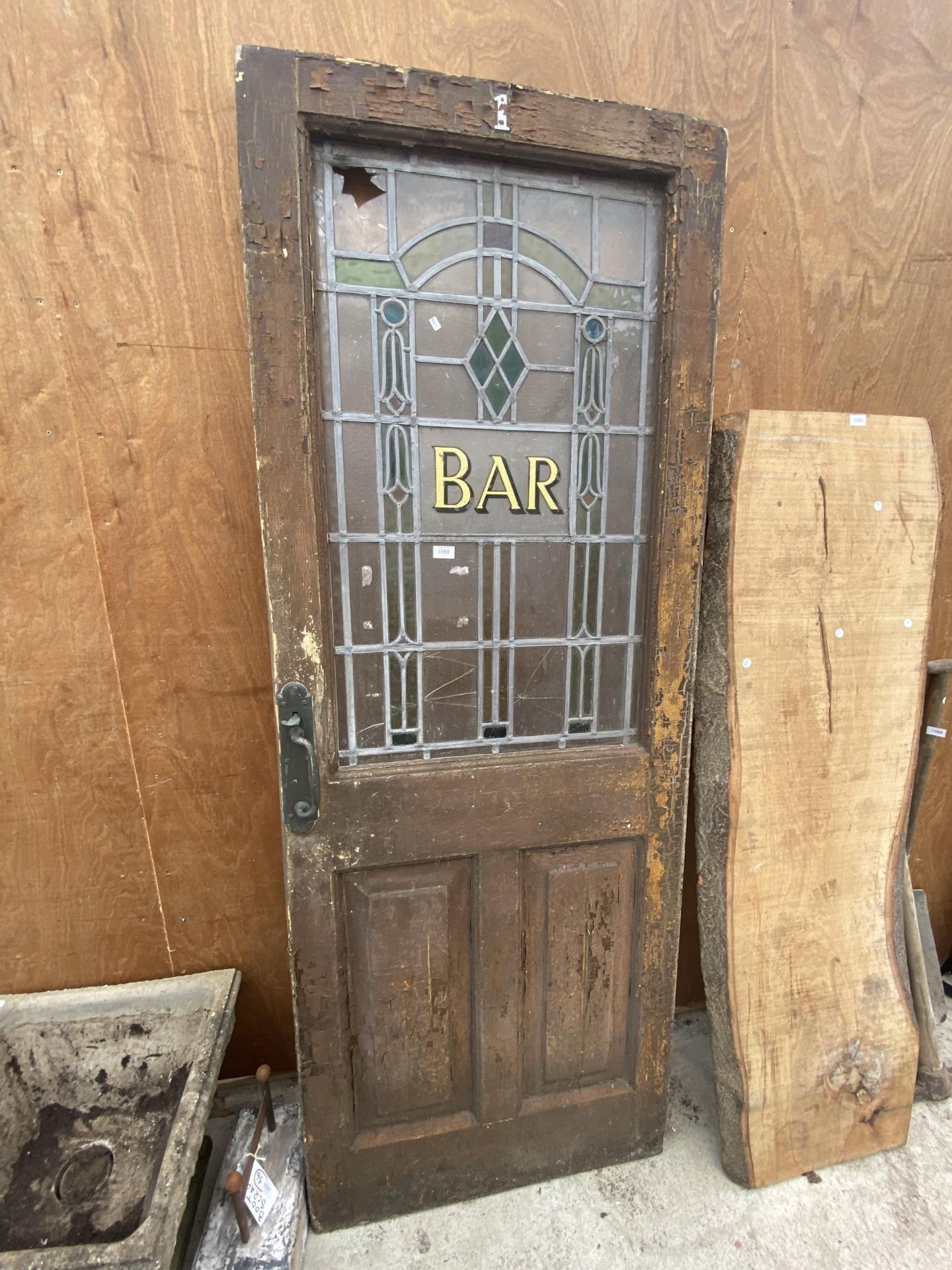 A VINTAGE WOODEN 'BAR' DOOR WITH GLAZED AND LEADED UPPER PORTION