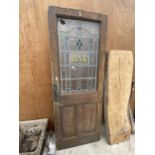 A VINTAGE WOODEN 'BAR' DOOR WITH GLAZED AND LEADED UPPER PORTION