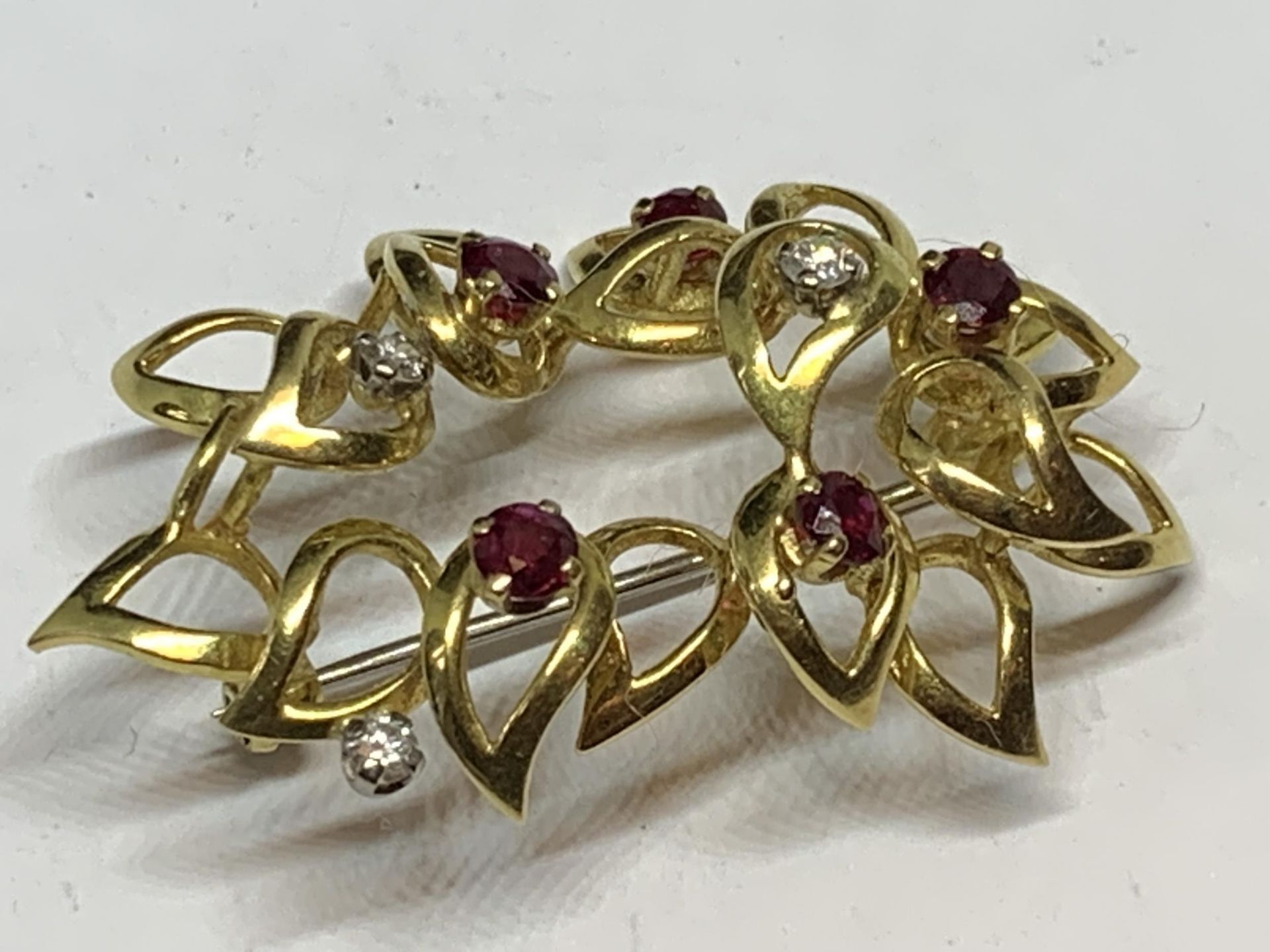 A 9 CARAT GOLD BROOCH SET WITH THREE DIAMOND AND FIVE RUBIES IN A PRESENTATION BOX