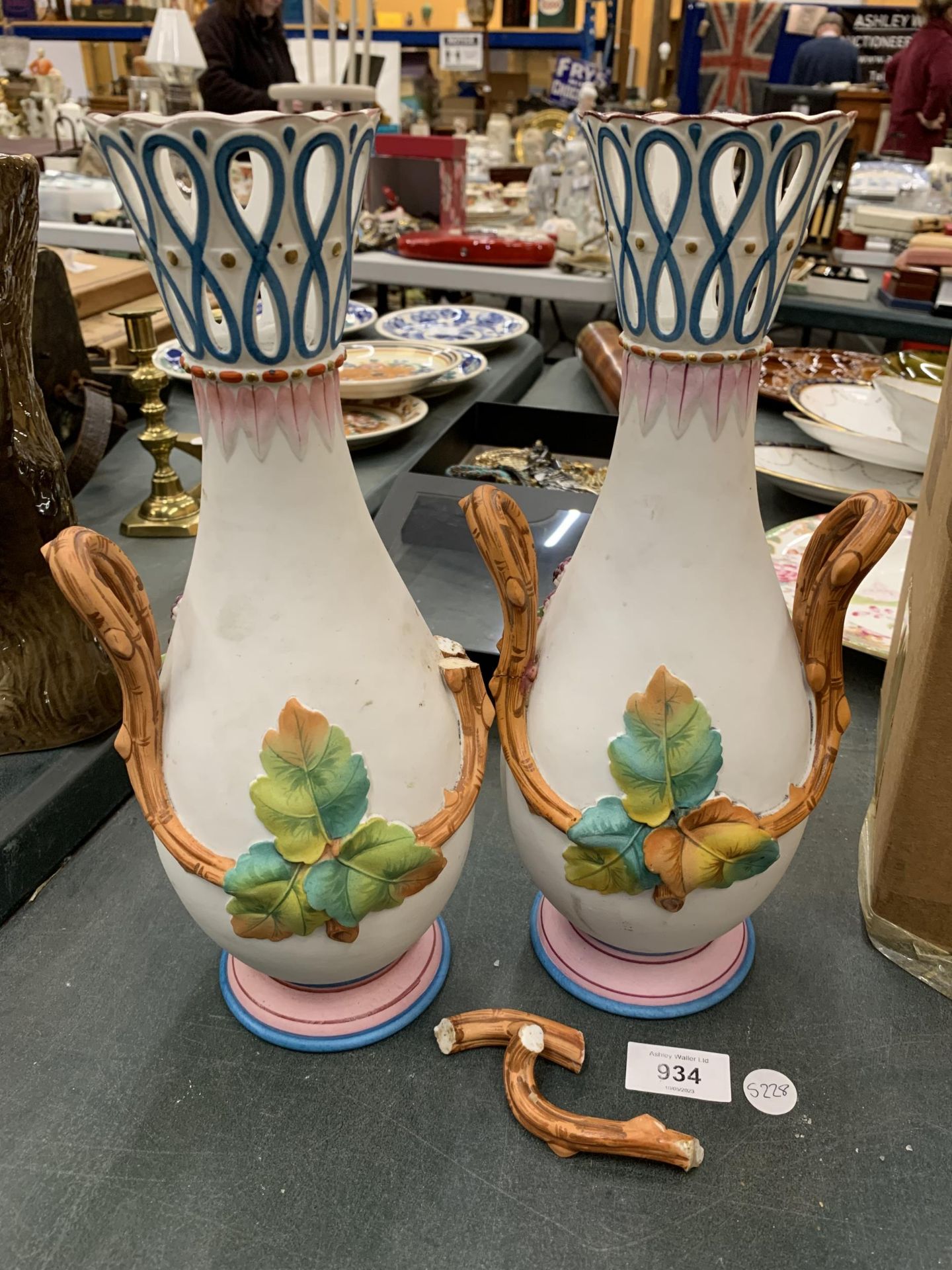 A PAIR OF TWIN HANDLED CONTINENTAL VASES, HANDLE A/F