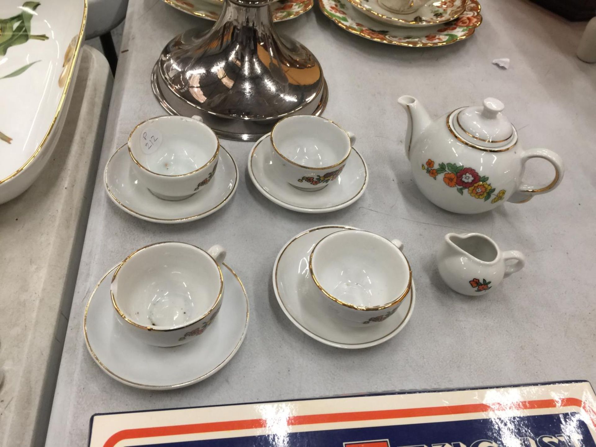 A VINTAGE CHILD'S CERAMIC TEASET TO INCLUDE FOOUR CUPS AND SAUCERS, A TEAPOT AND A CREAM JUG