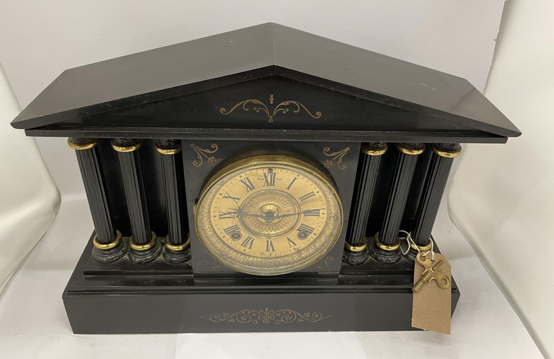 AN ANTIQUE BLACK SLATE MARBLE MANTLE CLOCK WITH TRIPLE CORINTHIAN COLUMNS AND GILT DESIGN DIAL, WITH