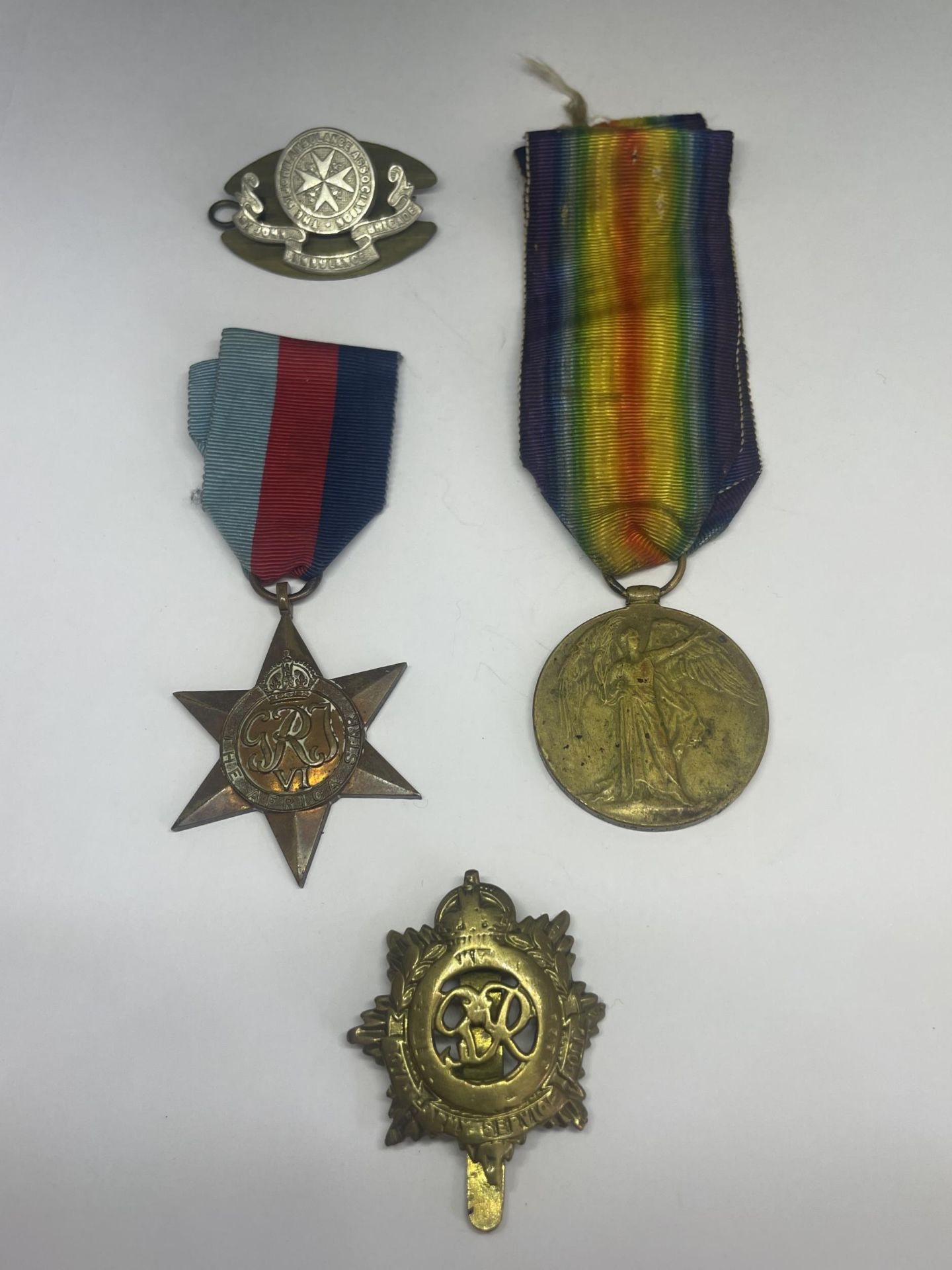 FOUR MILITARY MEDALS AND BADGES