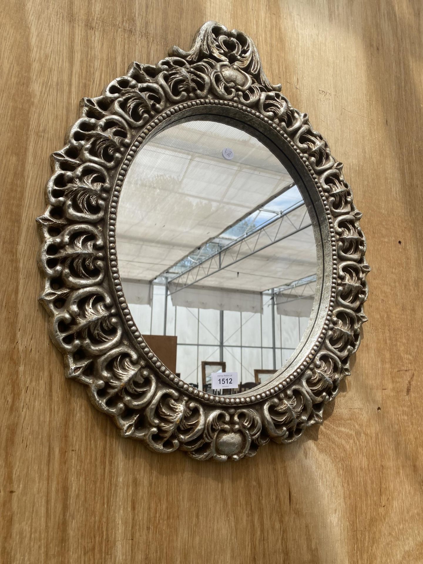 A DECORATIVE SILVER GILT FRAMED WALL MIRROR