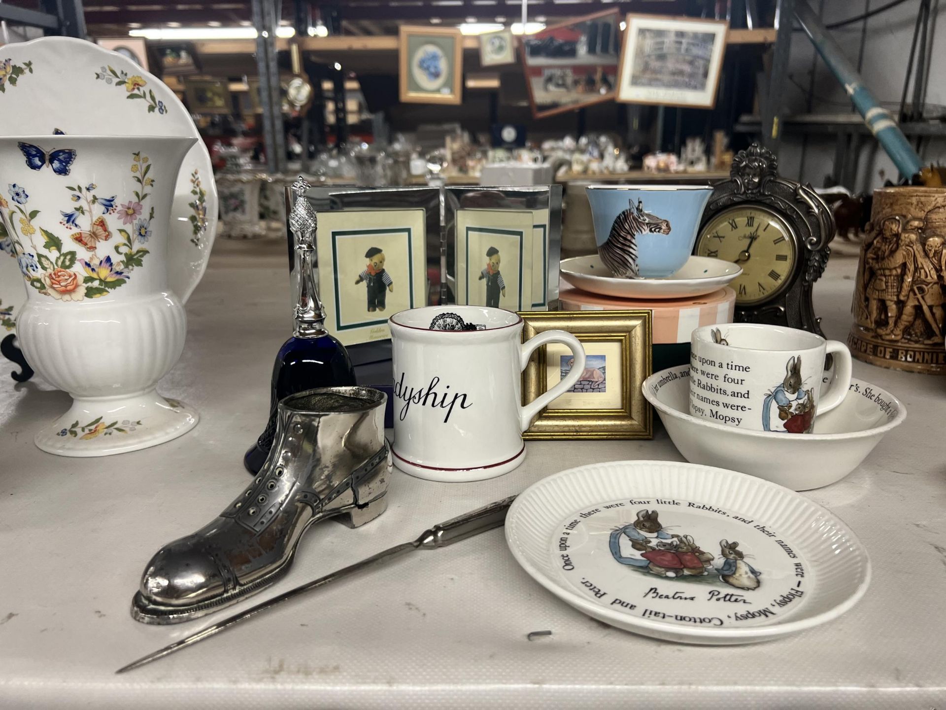 A MIXED LOT TO INCLUDE A WHITE METAL BOOT AND LETTER OPENER, WEDGWOOD PETER RABBIT MUG, BOWL AND
