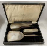 AN ART DECO CASED HALLMARKED SILVER FOUR PIECE ENGINE TURNED DRESSING TABLE SET, TWO BRUSHES, MIRROR