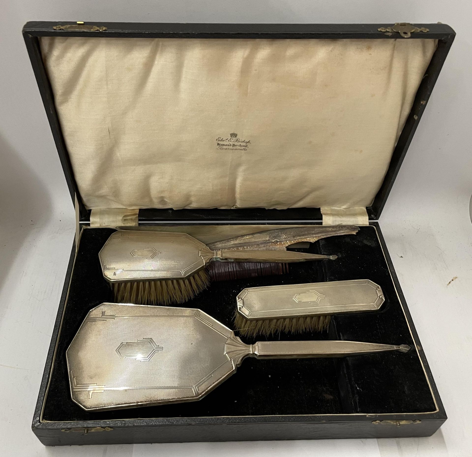 AN ART DECO CASED HALLMARKED SILVER FOUR PIECE ENGINE TURNED DRESSING TABLE SET, TWO BRUSHES, MIRROR