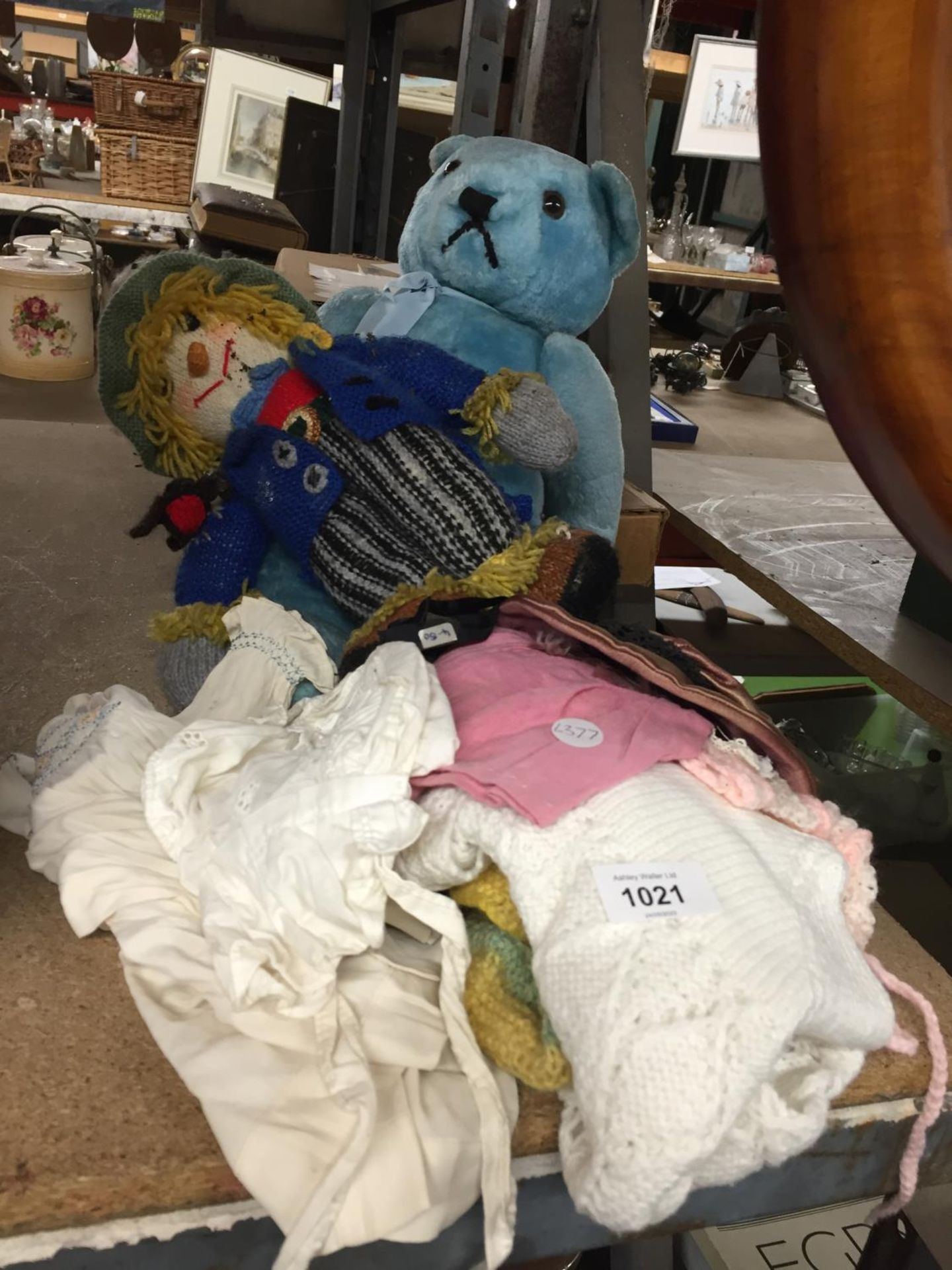 A VINTAGE BLUE TEDDY AND KNITTED CLOWN PLUS A QUANTITY OF CLOTHES
