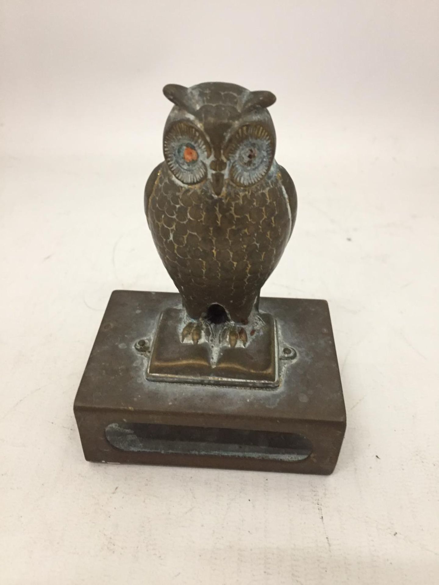 A VINTAGE BRASS MATCHBOX HOLDER WITH A BRASS OWL FIGURE ON TOP