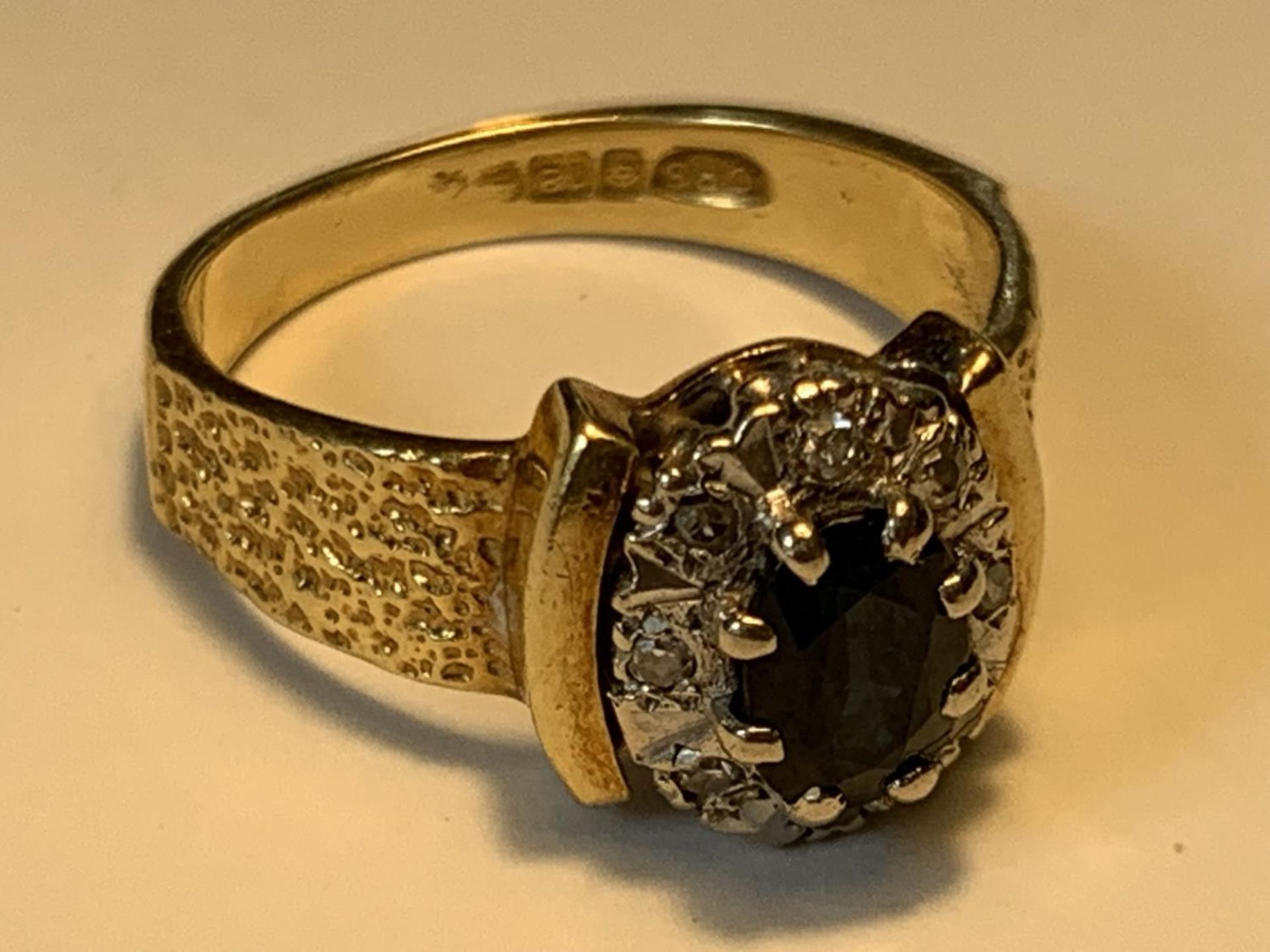 AN 18 CARAT GOLD RING WITH A CENTRE SAPPHIRE SURROUNDED BY DIAMONDS SIZE J