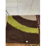 A MODERN GREEN AND BROWN RUG