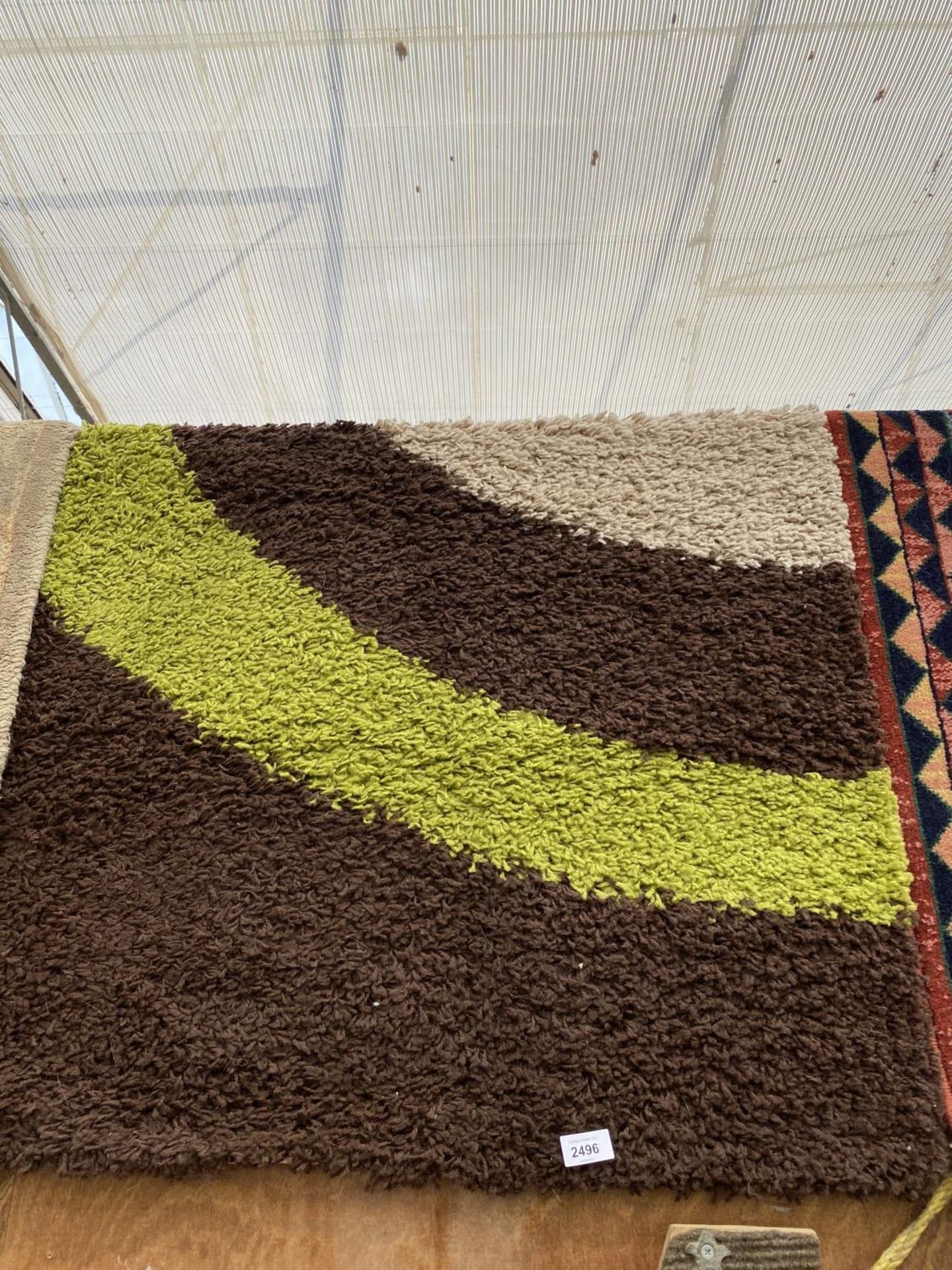 A MODERN GREEN AND BROWN RUG