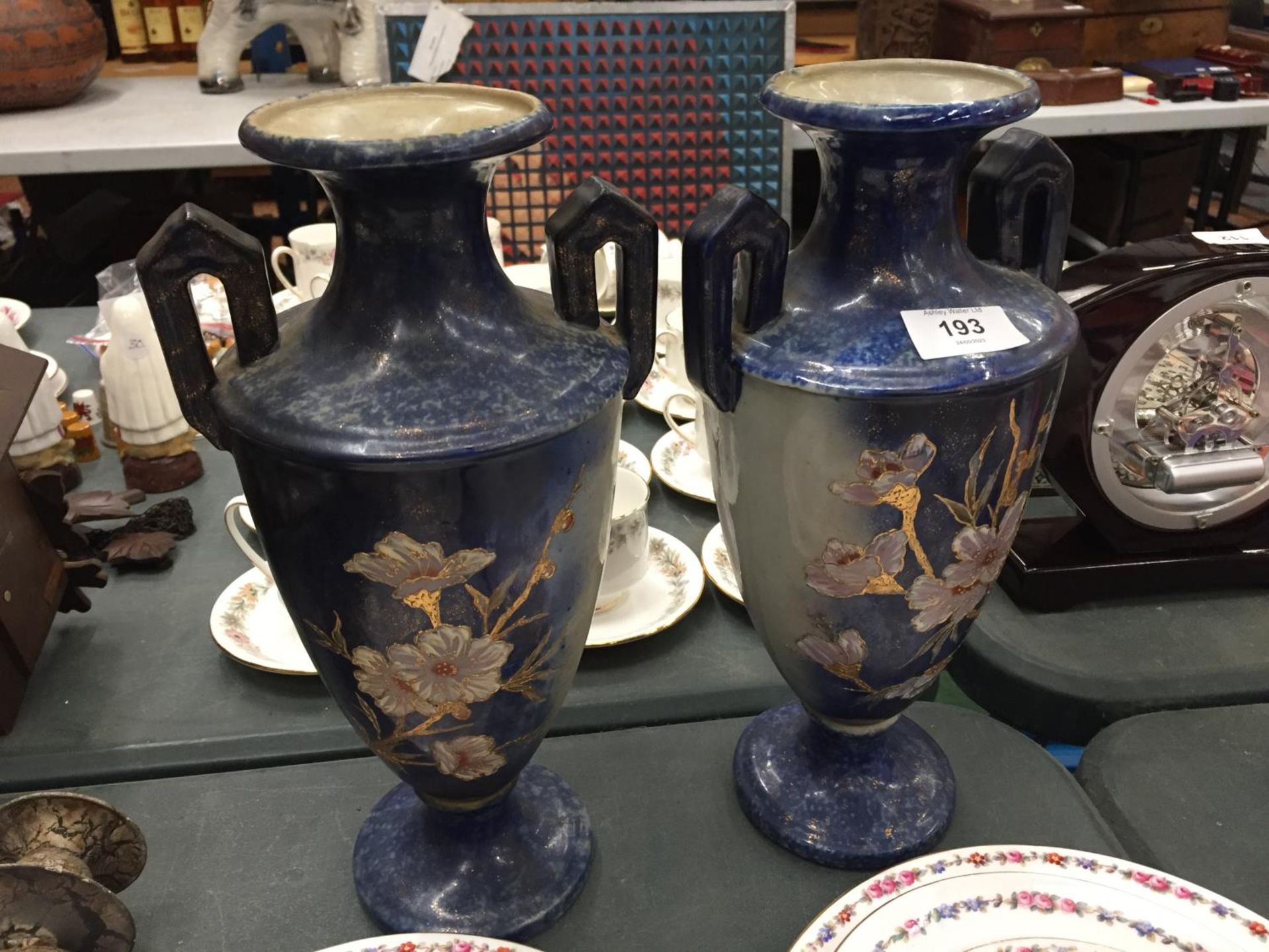 A PAIR OF TWIN HANDLED VASES MARKED TO THE BASE 'TRADITIONAL VICTOR' HEIGHT 33CM