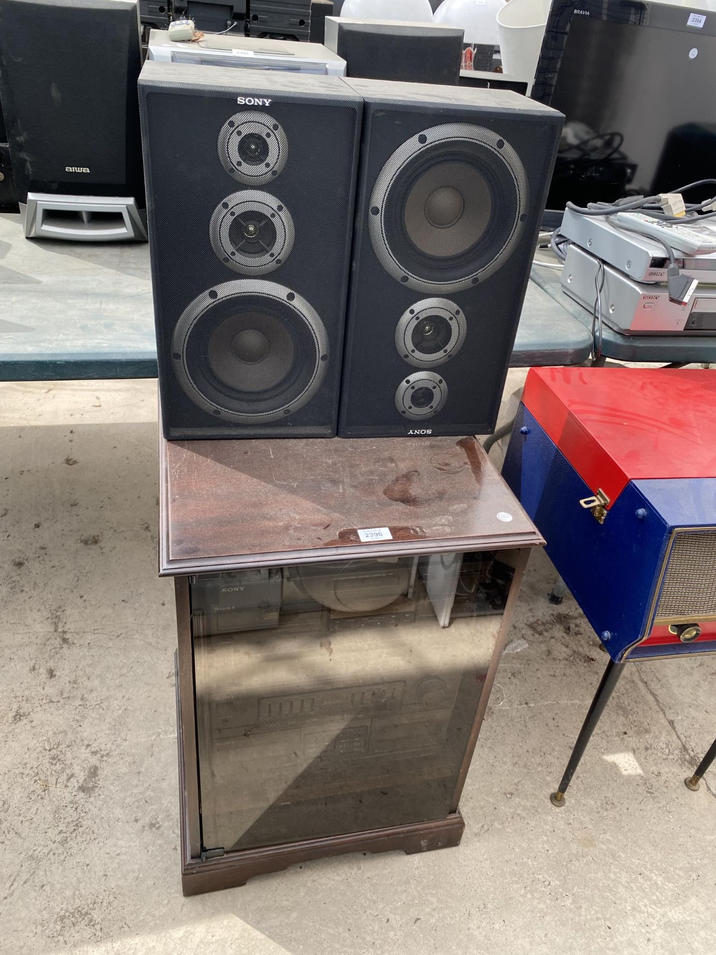 A RECORD CABINET CONTAINING A SONY STEREO SYSTEM AND TWO SONY SPEAKERS