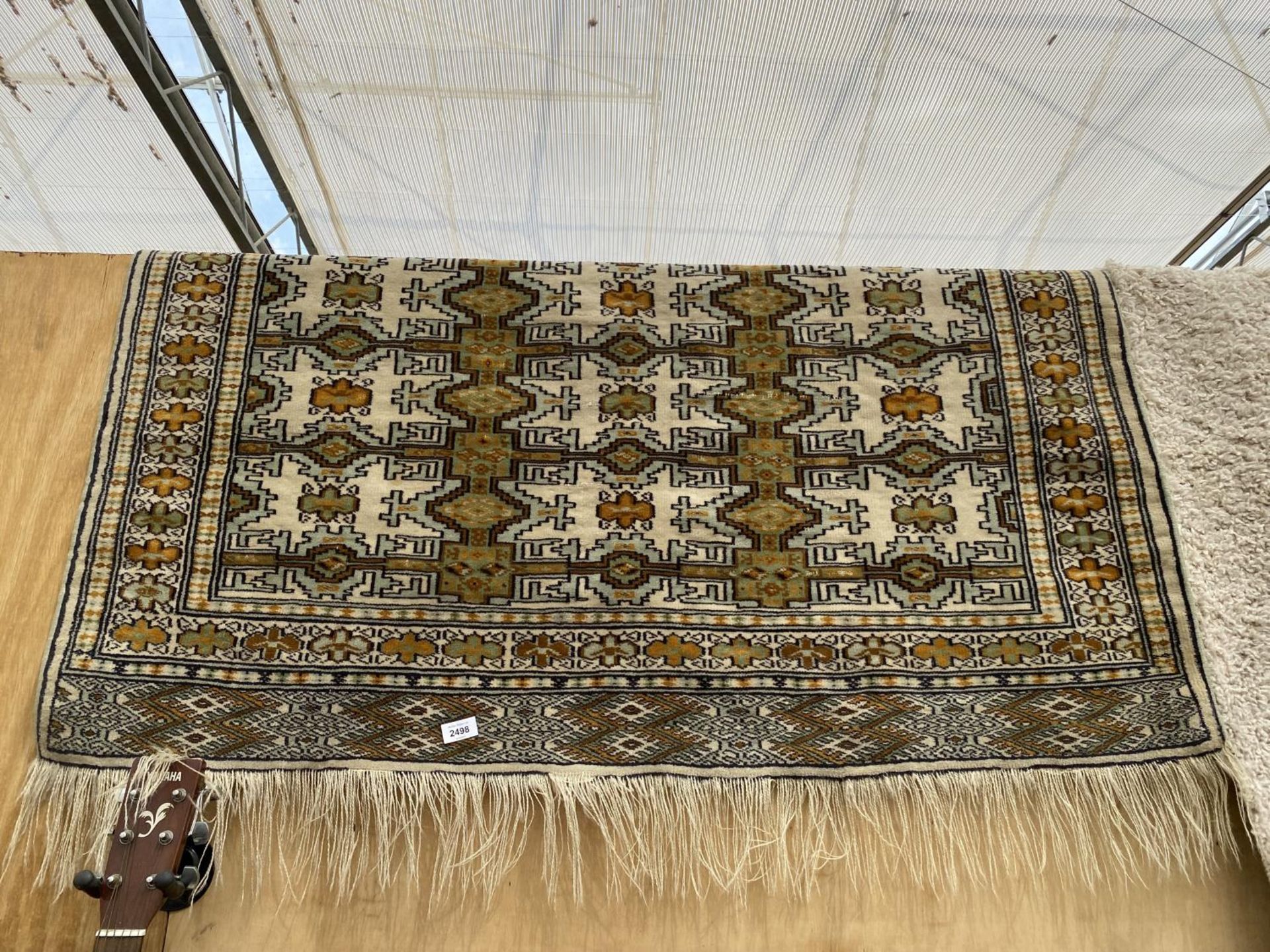 A YELLOW PATTERNED FRINGED RUG