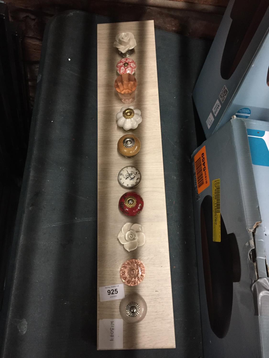 A COLLECTION OF MODERN DRAWER KNOB SAMPLES ON A WOODEN BACK