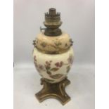 AN ANTIQUE CERAMIC AND BRASS OIL LAMP WITH FLORAL DESIGN