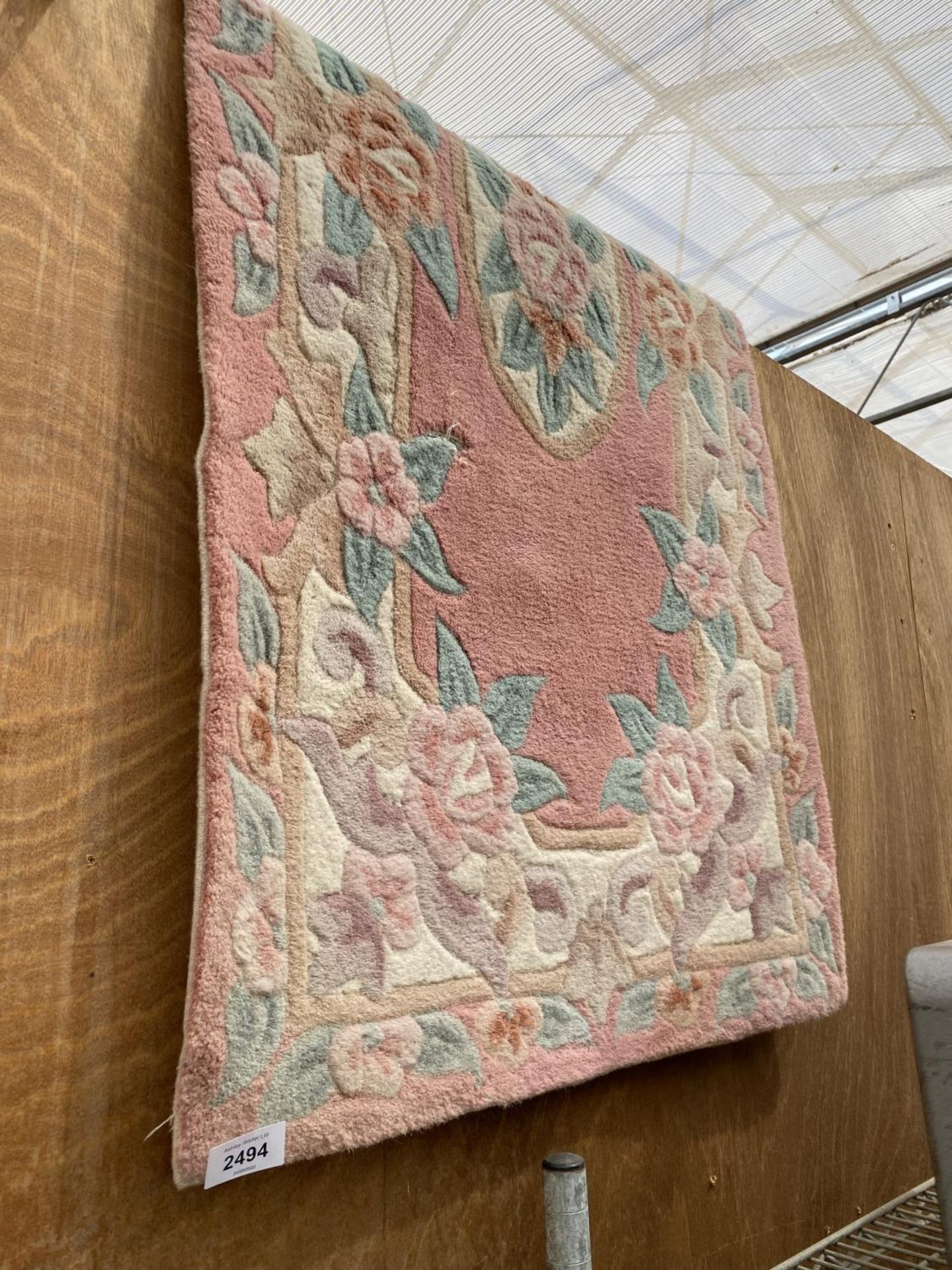 A SMALL PINK PATTERNED RUG