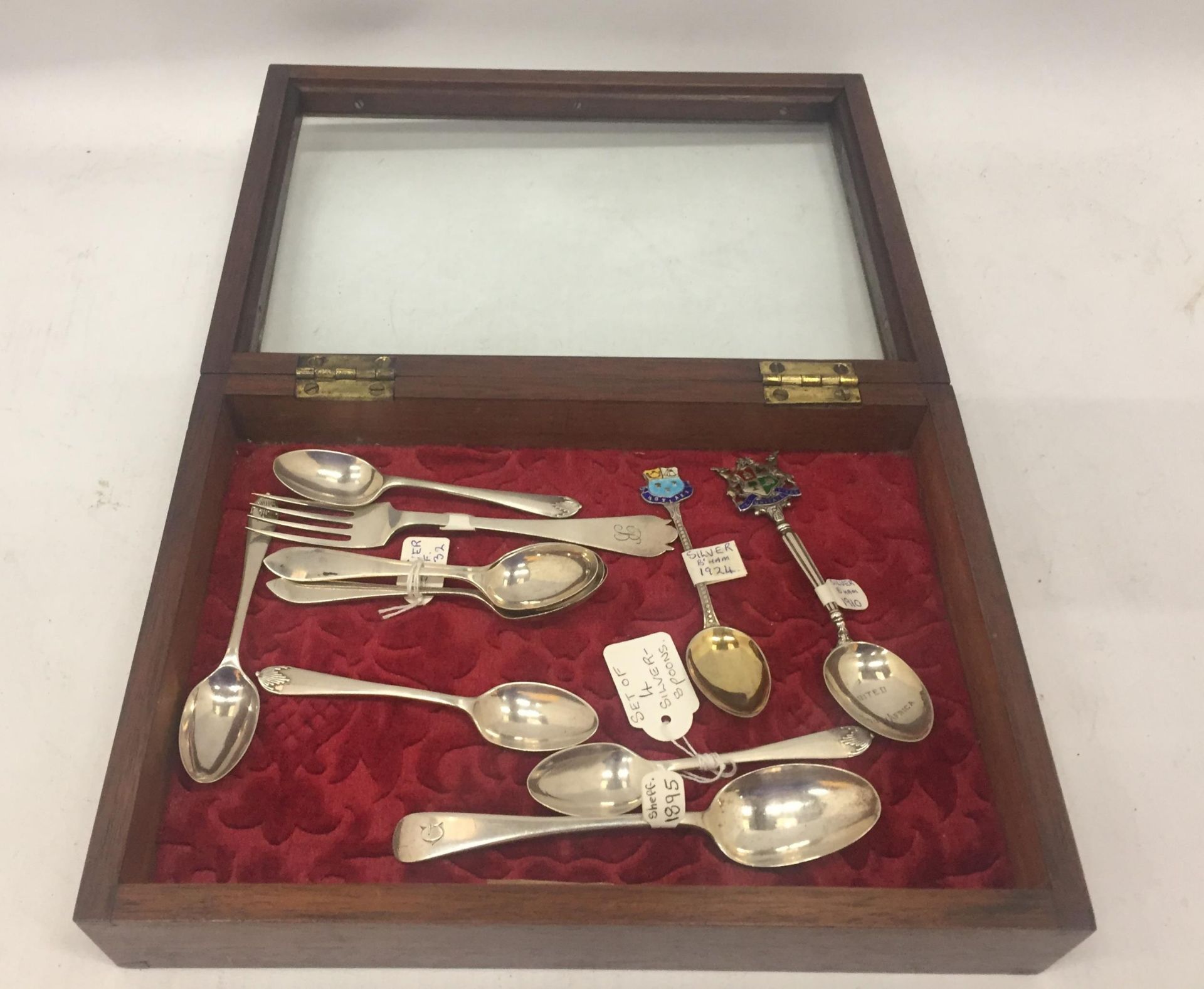 A DISPLAY BOX CONTAINING ASSORTED HALLMARKED SILVER FLATWARE - SET OF FOUR, ENAMEL TOP EXAMPLES,