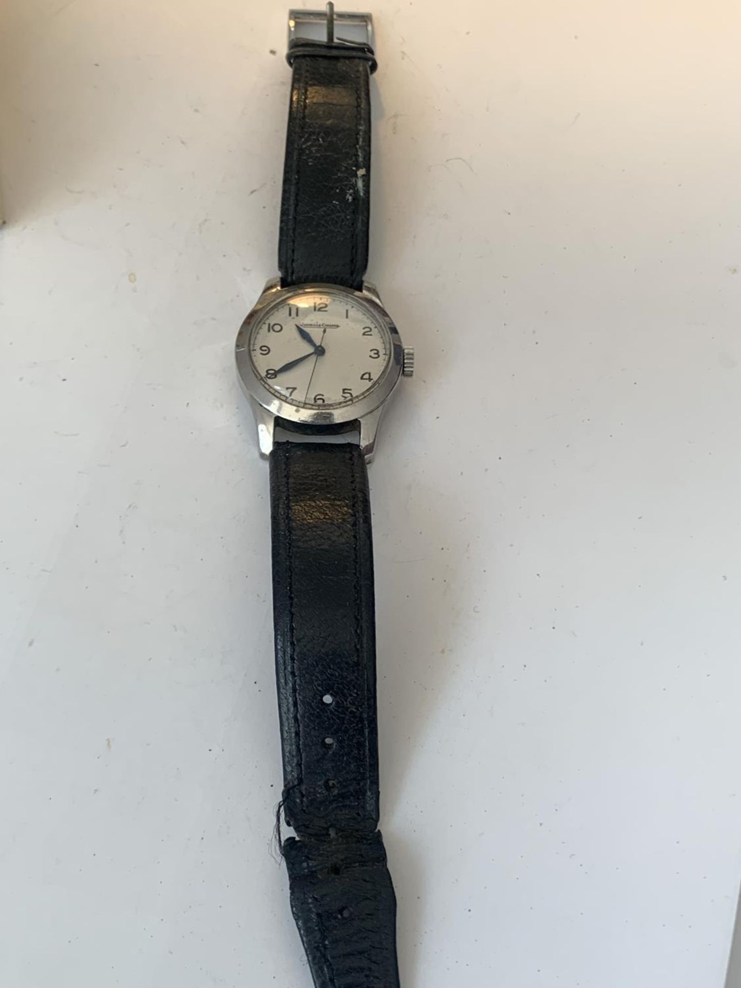 A VINTAGE JAEGER LeCOUTRE WRIST WATCH WITH WHITE FACE AND BLACK LEATHER STRAP POSSIBLY MILITARY.