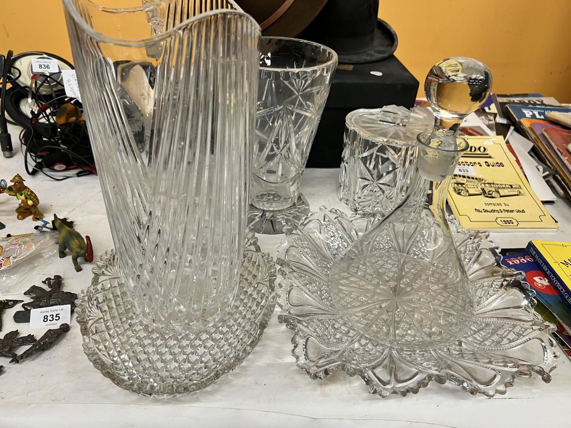 A QUANTITY OF GLASS WARE TO INCLUDE VASES, DECANTERS, SERVING BOWLS, ETC.,