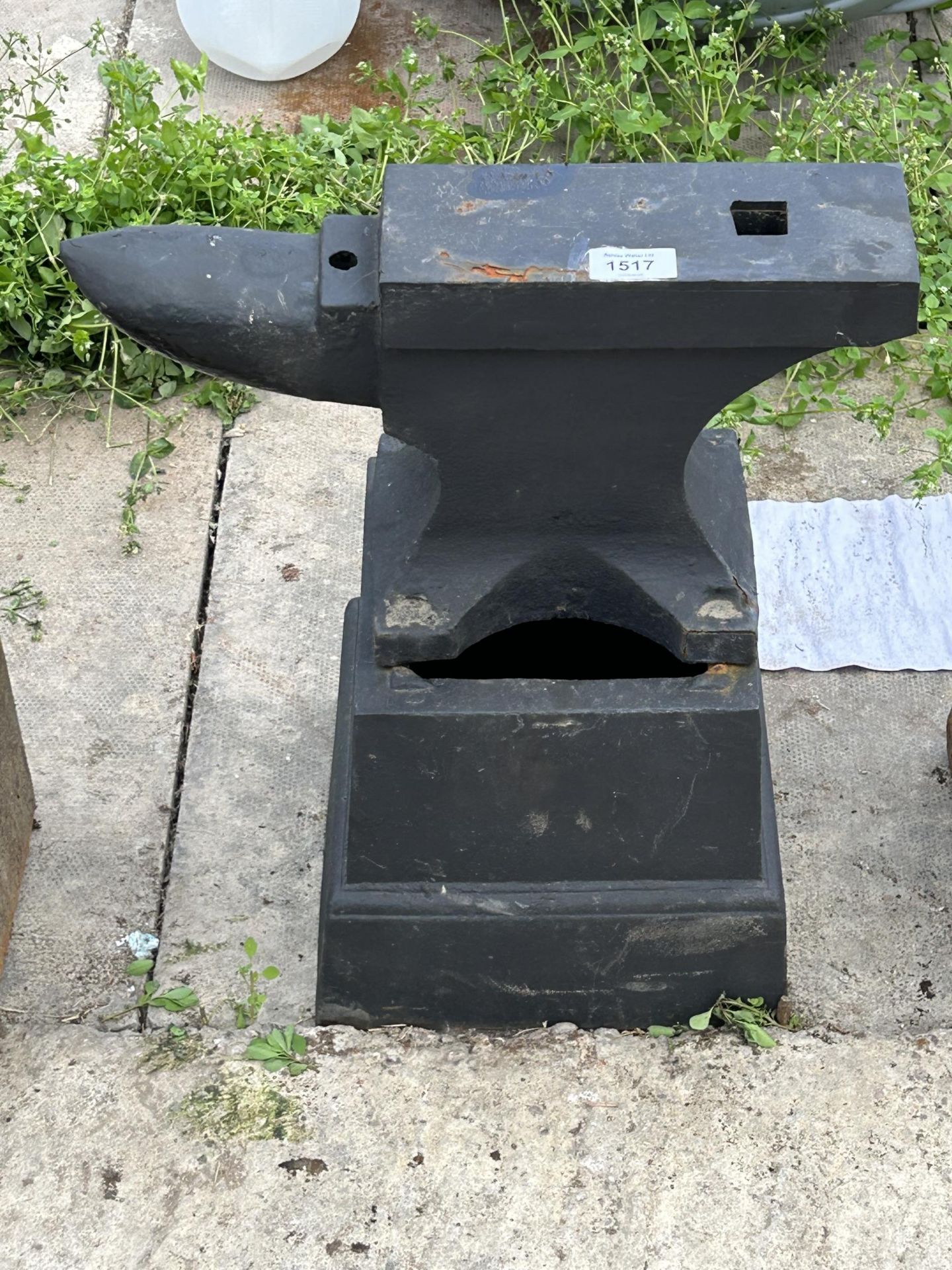 A SMALL VINTAGE CAST IRON BLACKSMITHS ANVIL AND CAST IRON STAND (ANVIL H:21CM L:39CM STAND H:21CM)