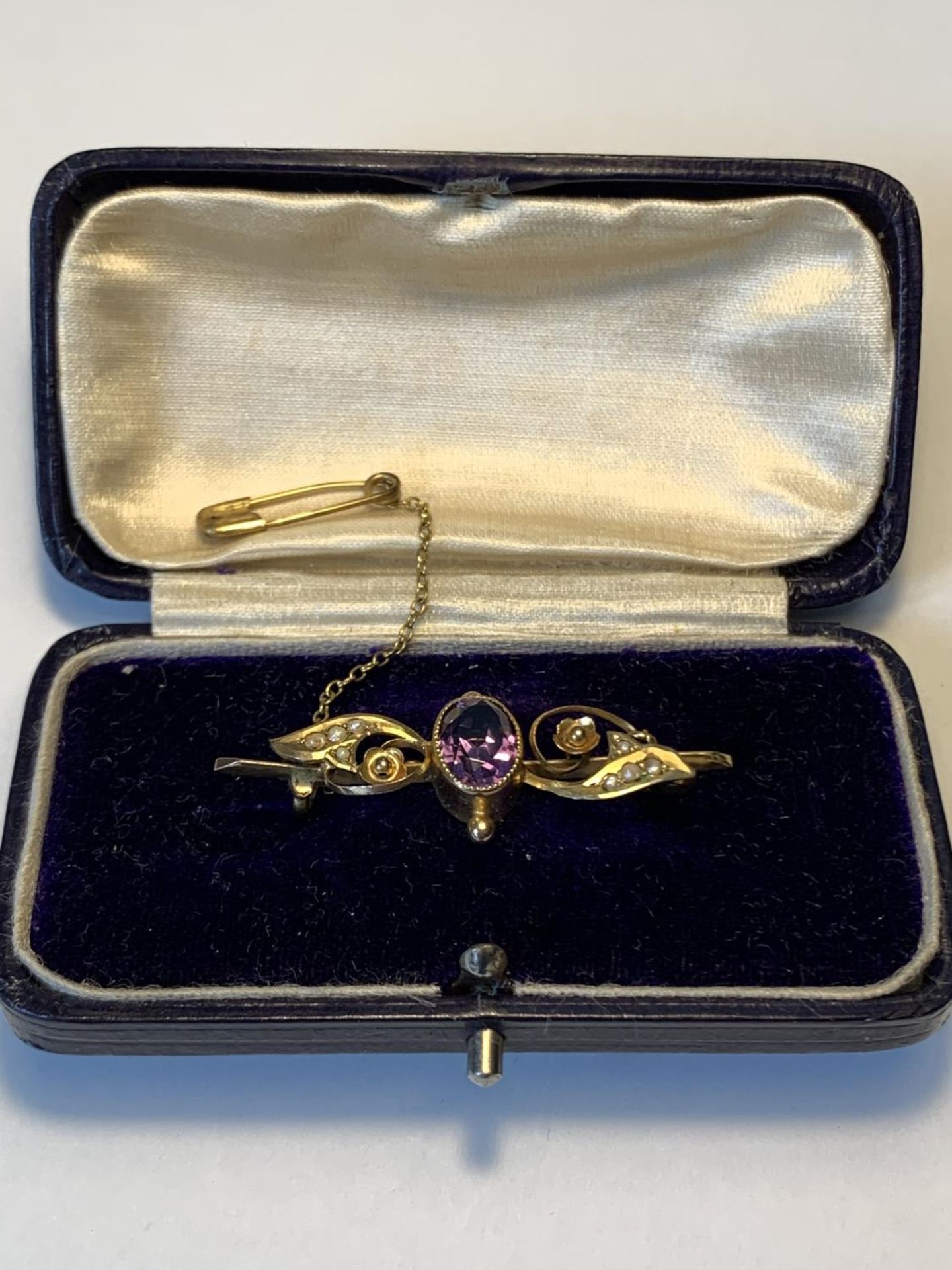 A 9 CARAT GOLD BROOCH WITH AMETHYST AND SEE PEARLS GROSS WEIGHT 2.52 GRAMS IN A PRESENTATION BOX