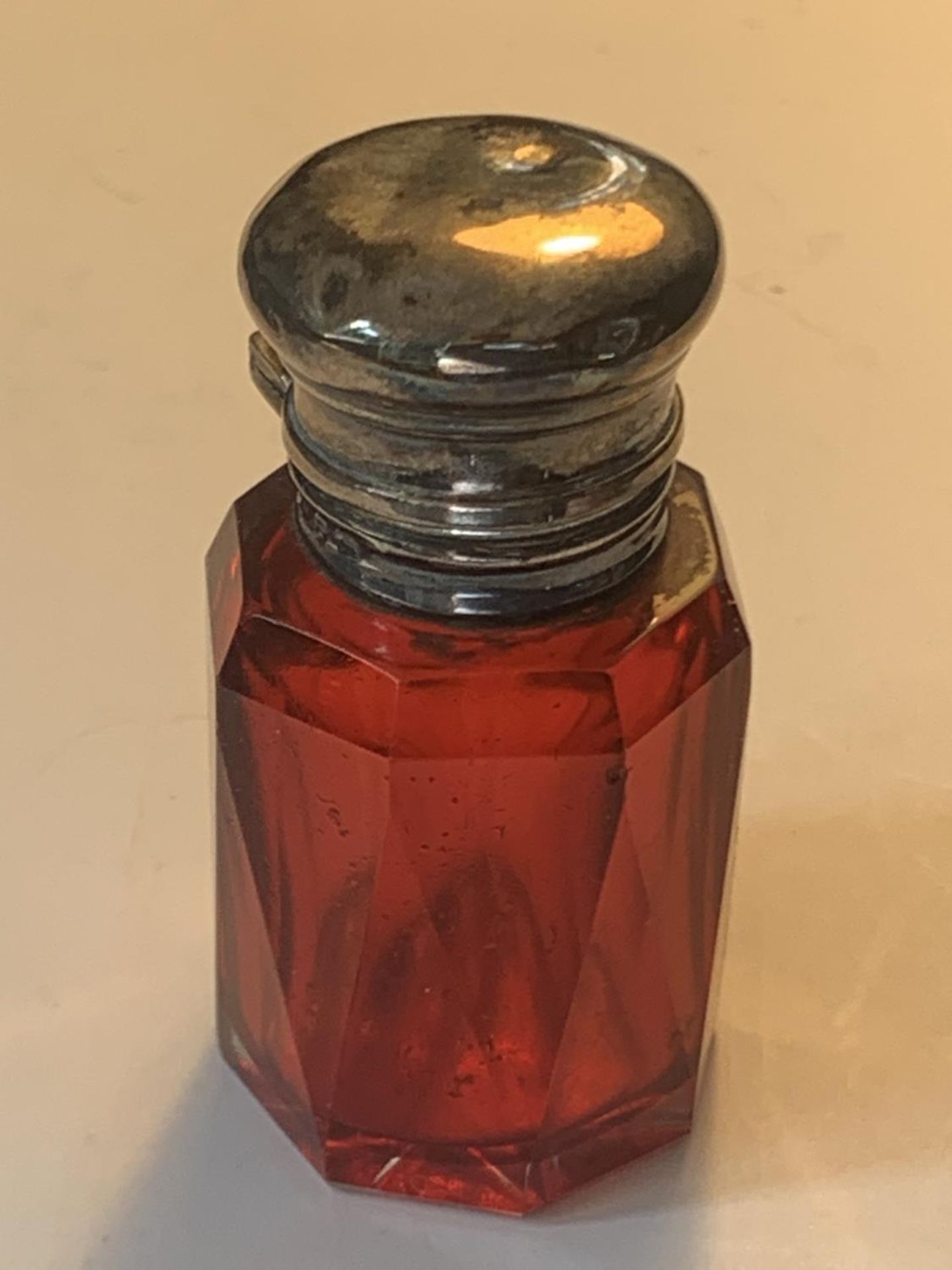 A CRANBERRY GLASS PERFUME BOTTLE WITH HALLMARKED BIRMINGHAM SILVER TOP AND GLASS STOPPER