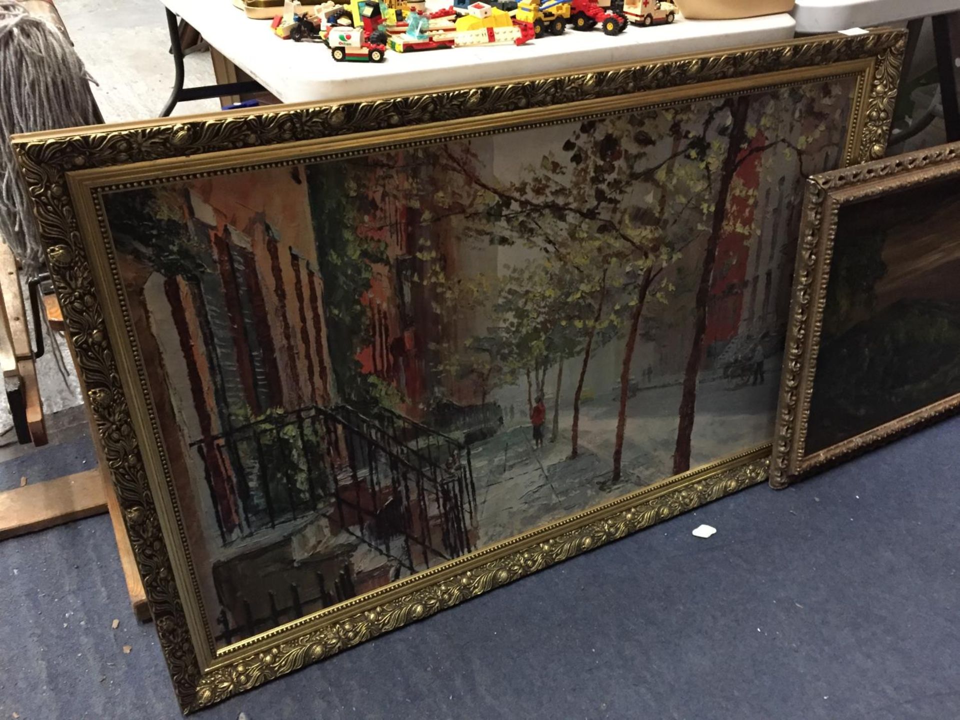 A LARGE PRINT OF A STREET SCENE IN A GILT FRAME 112CM X 71CM PLUS AN OIL ON BOARD 84CM X 55CM