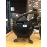 A VINTAGE BRASS COAL SCUTTLE ON LION CLAW FEET