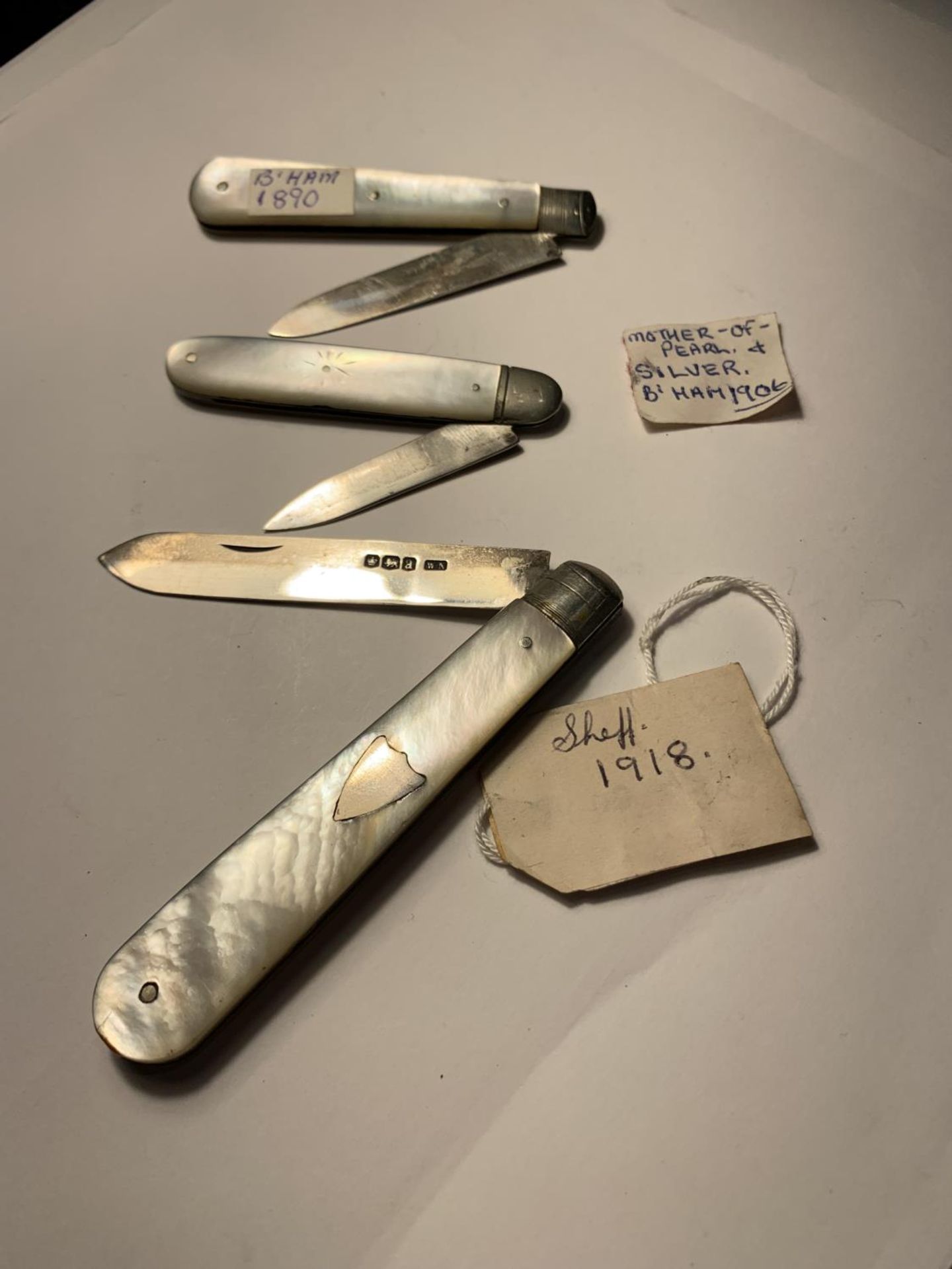 THREE MOTHER OF PEARL FRUIT KNIVES TWO HALLMARKED BIRMINGHAM 1890 AND 1906, ONE SHEFFIELD 1918