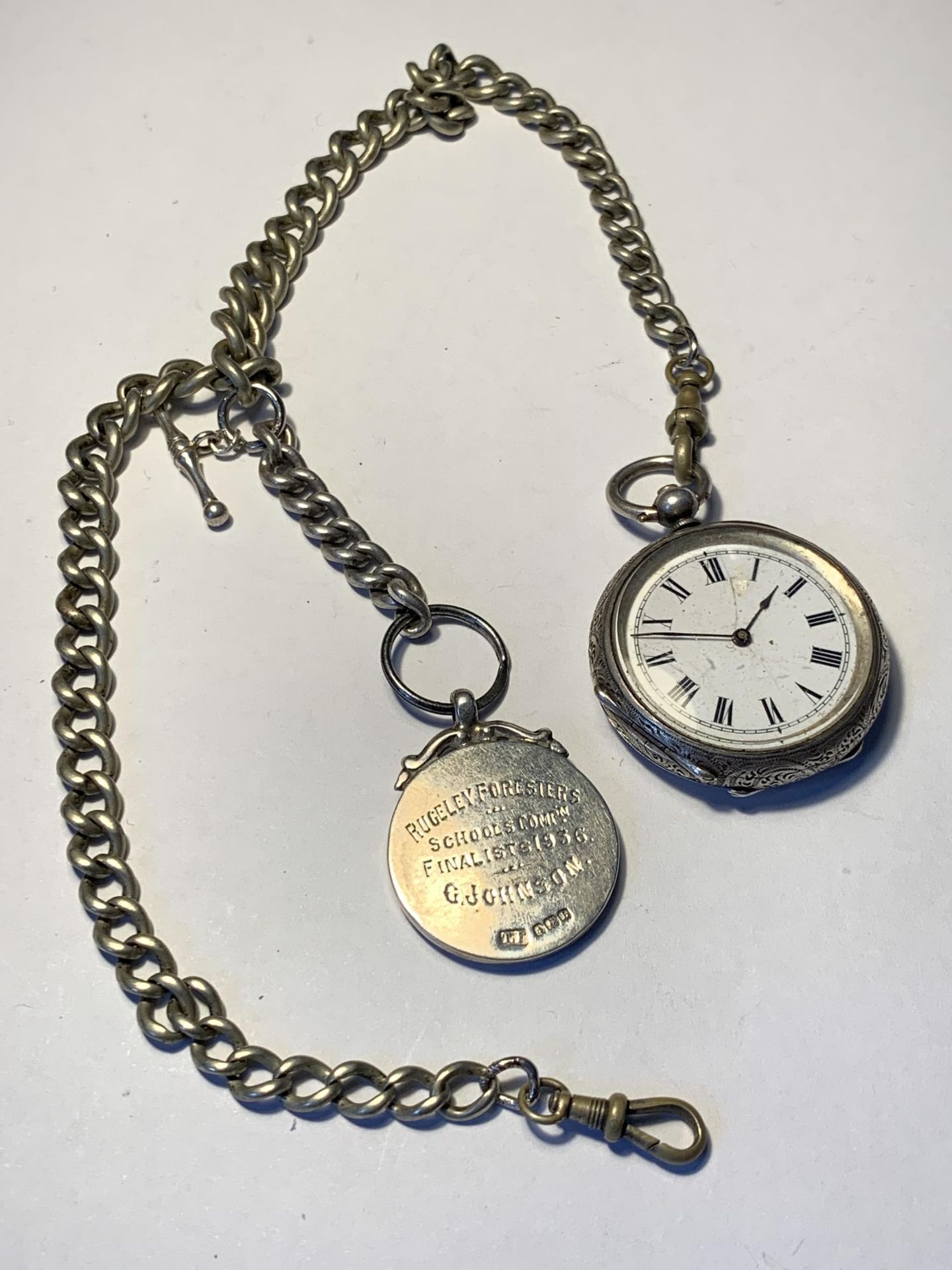 A POCKET WATCH ON A CHAIN WITH A HALLMARKED BIRMINGHAM SILVER FOB