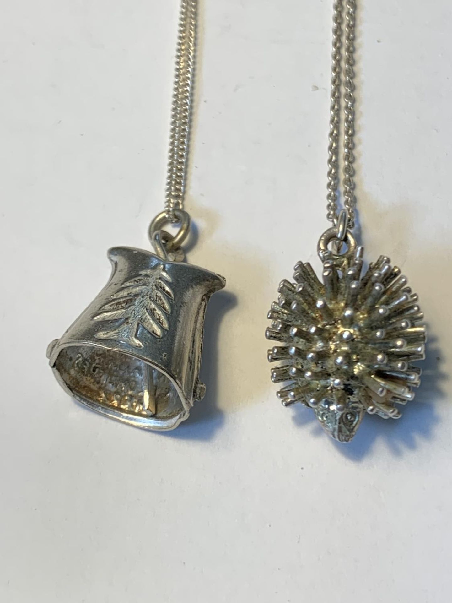 TWO SILVER NECLACES WITH PENDANTS TO INCLUDE A HEDGEHOG AND A BELL - Image 2 of 3