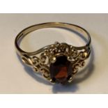 A 9 CARAT GOLD RING WITH A CENTRE GARNET SIZE P GROSS WEIGHT 1.57 GRAMS IN A PRESENTATION BOX