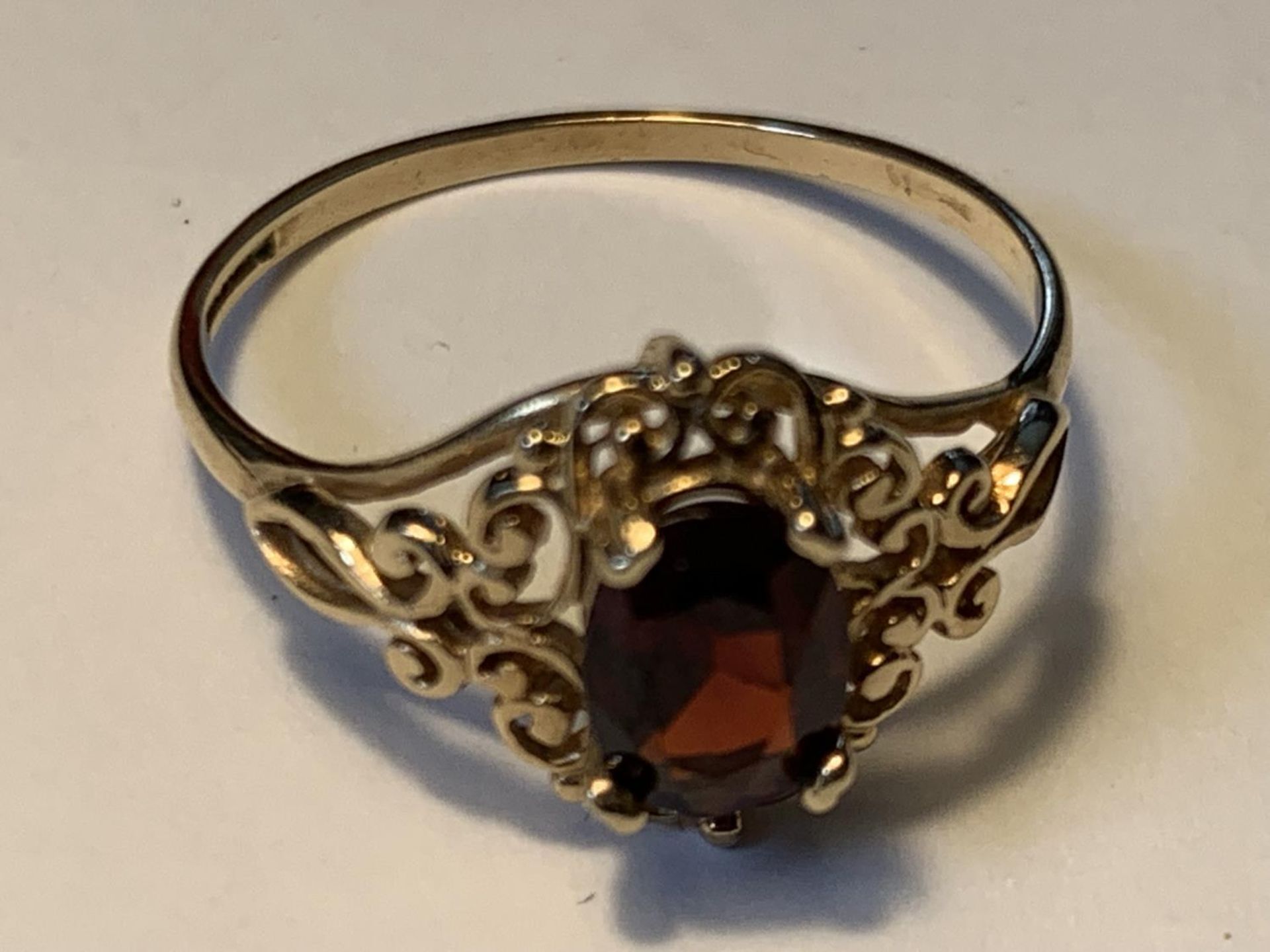 A 9 CARAT GOLD RING WITH A CENTRE GARNET SIZE P GROSS WEIGHT 1.57 GRAMS IN A PRESENTATION BOX