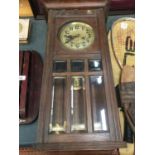 A VINTAGE MAHOGANY CASED WALL CLOCK WITH BEVELLED GLASS TO THE FRONT, COMPLETE WITH PENDULUM AND