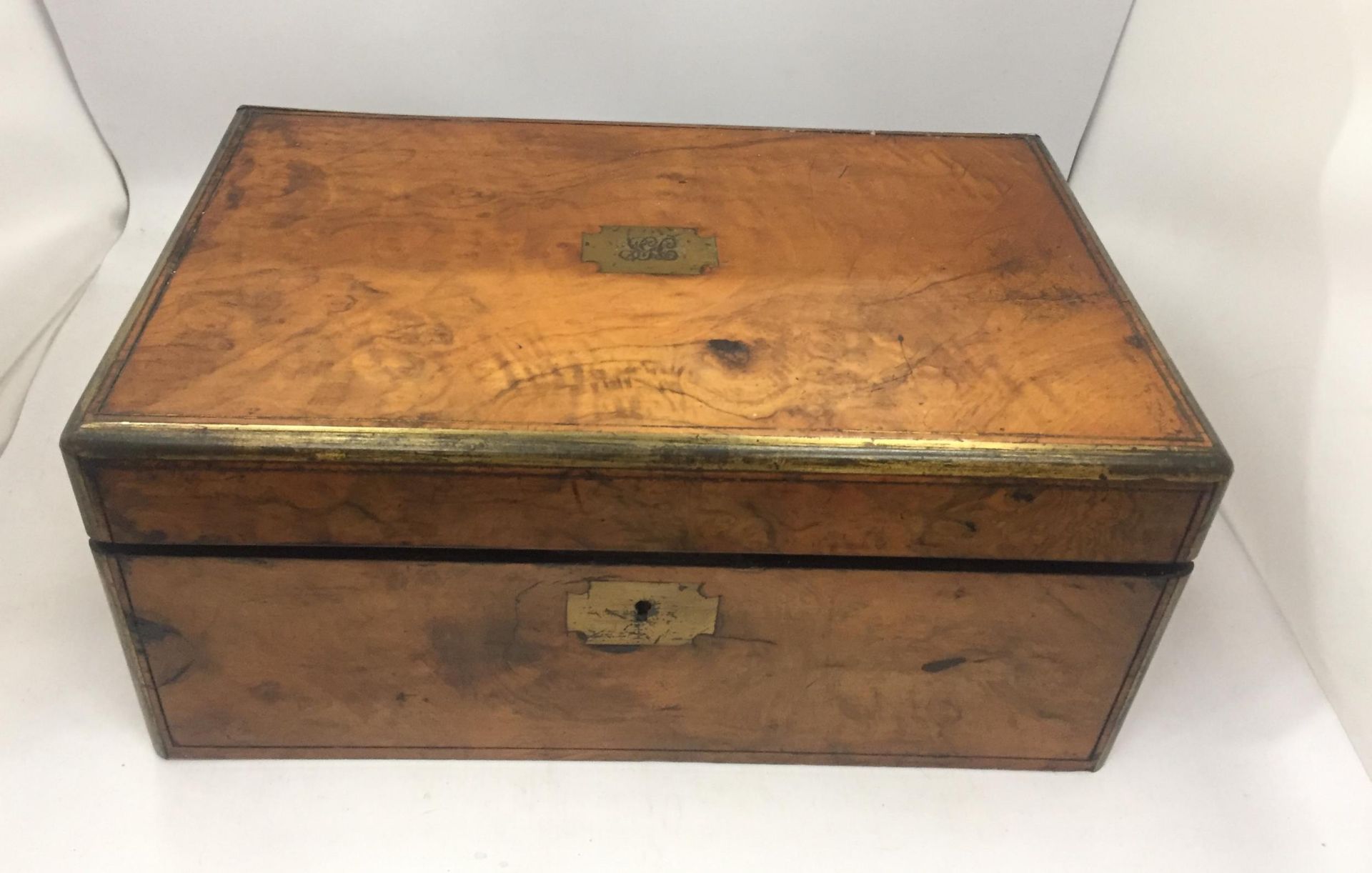 AN EARLY 20TH CENTURY WALNUT AND BRASS WRITING SLOPE WITH INNER BLACK LEATHER AND GILT SLOPE AND