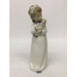 A NAO FIGURINE OF A GIRL WITH DOLL - 24.5 CM