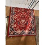 A SMALL RED PATTERNED RUG
