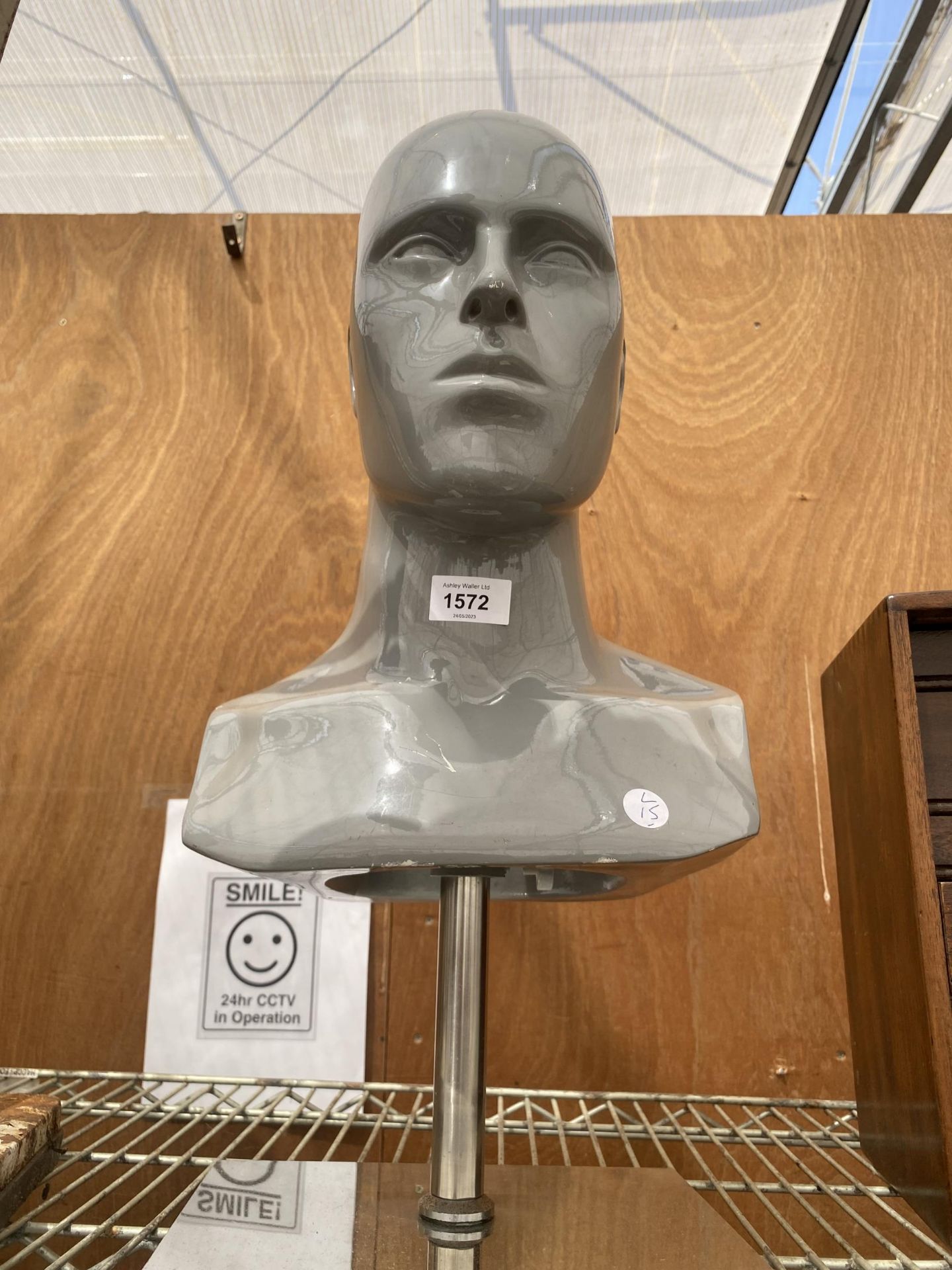 A RETRO FIBREGLASS MANNEQUIN HEAD ON A STEEL BASE