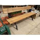 A LARGE REFURBISHED WOODEN SLATTED BENCH WITH 'KNOTTY' CAST IRON BENCH ENDS