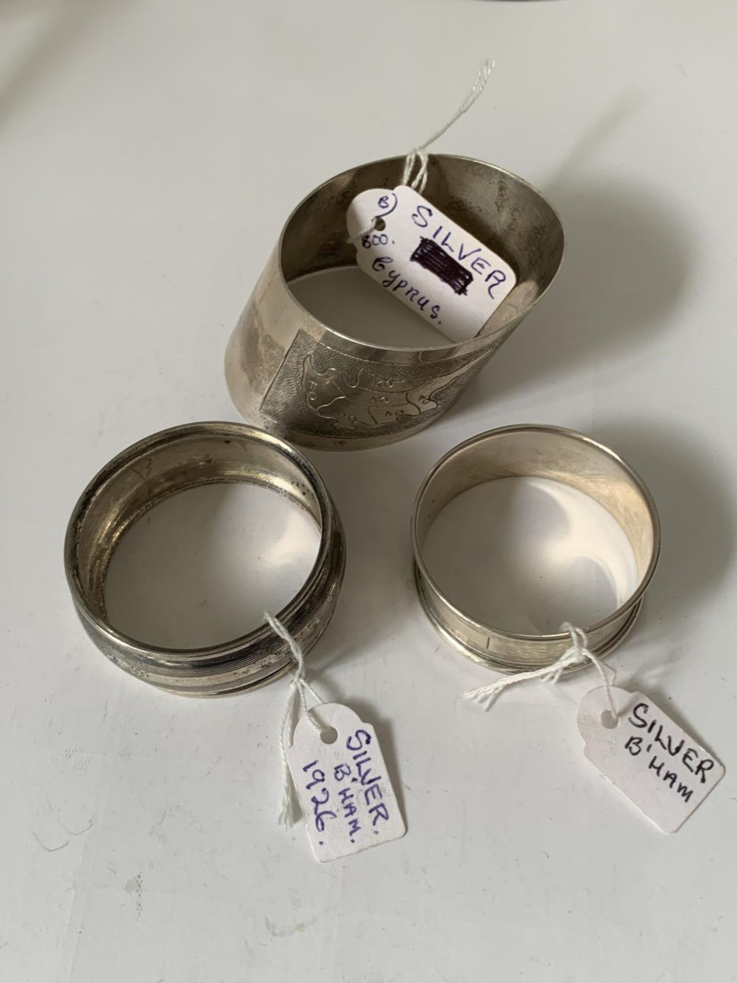 TWO HALLMARKED BIRMINGHAM SILVER NAPKIN RINGS AND A FURTHER SILVER RING WITH A MAP OF CYPRUS